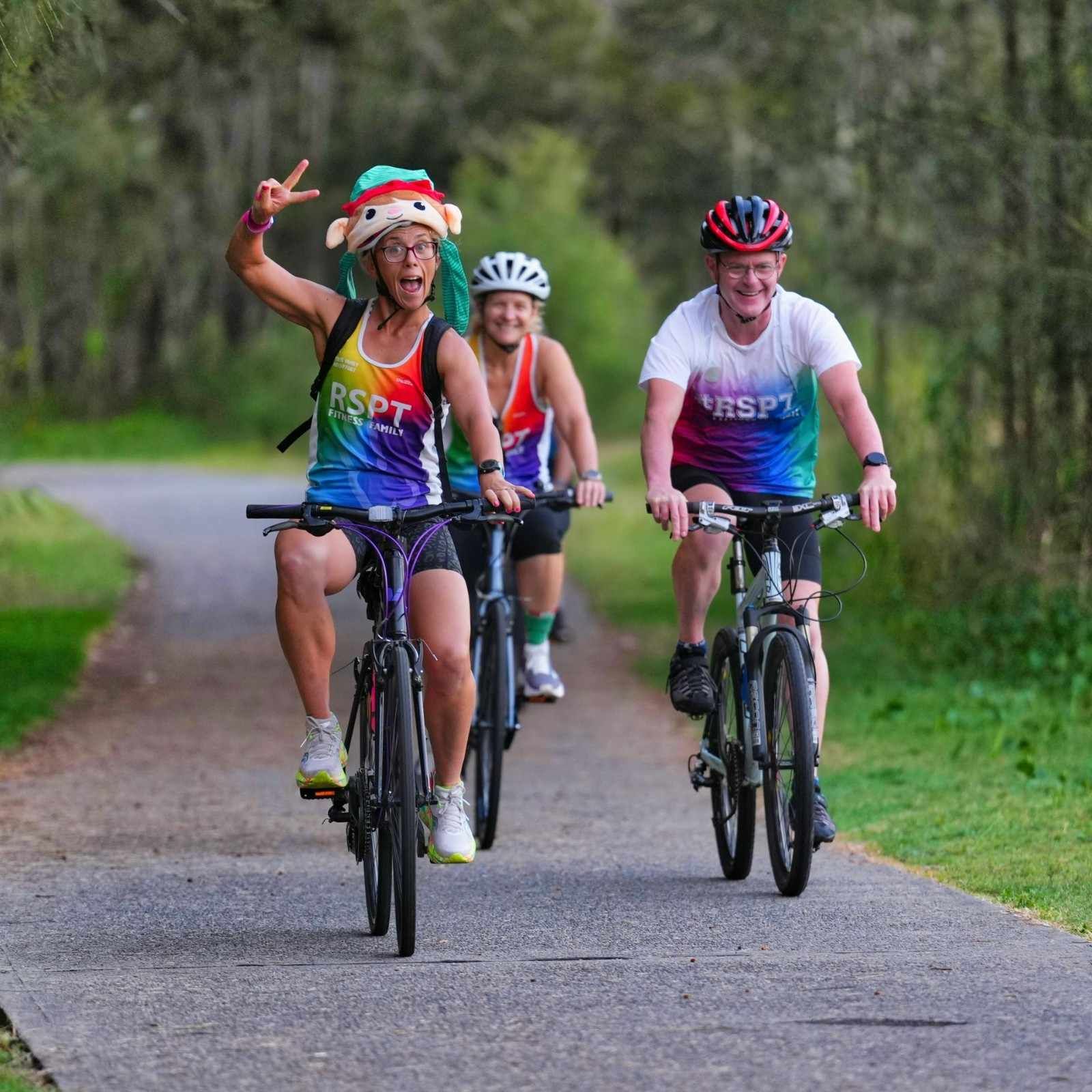 Three People Cycling on A Path, One in A Colorful Hat Raises Two Fingers — Run Fest in Port Macquarie, NSW