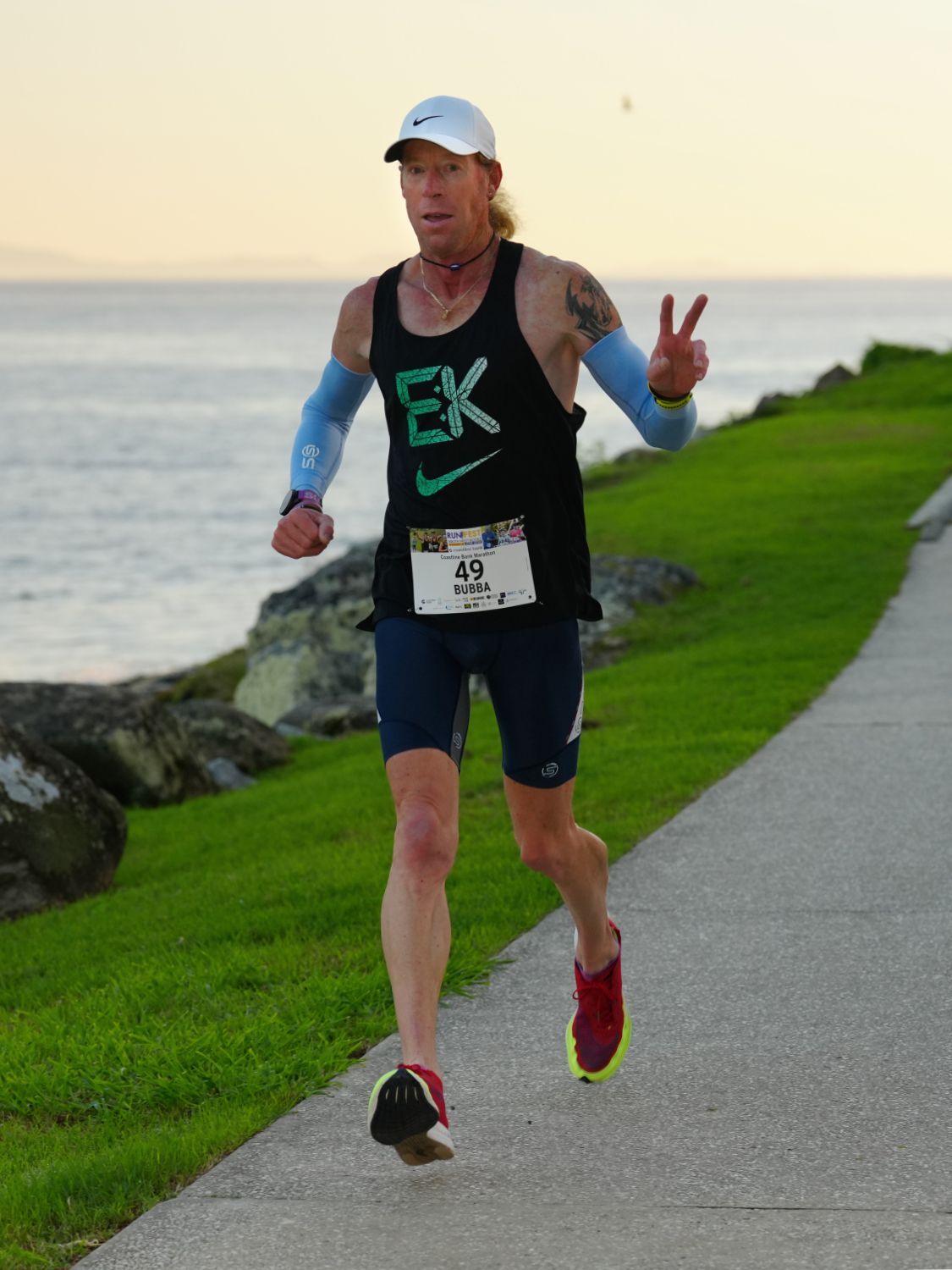 A Woman Is Running On A Sidewalk With Trees In The Background — Run Fest in South West Rocks, NSW