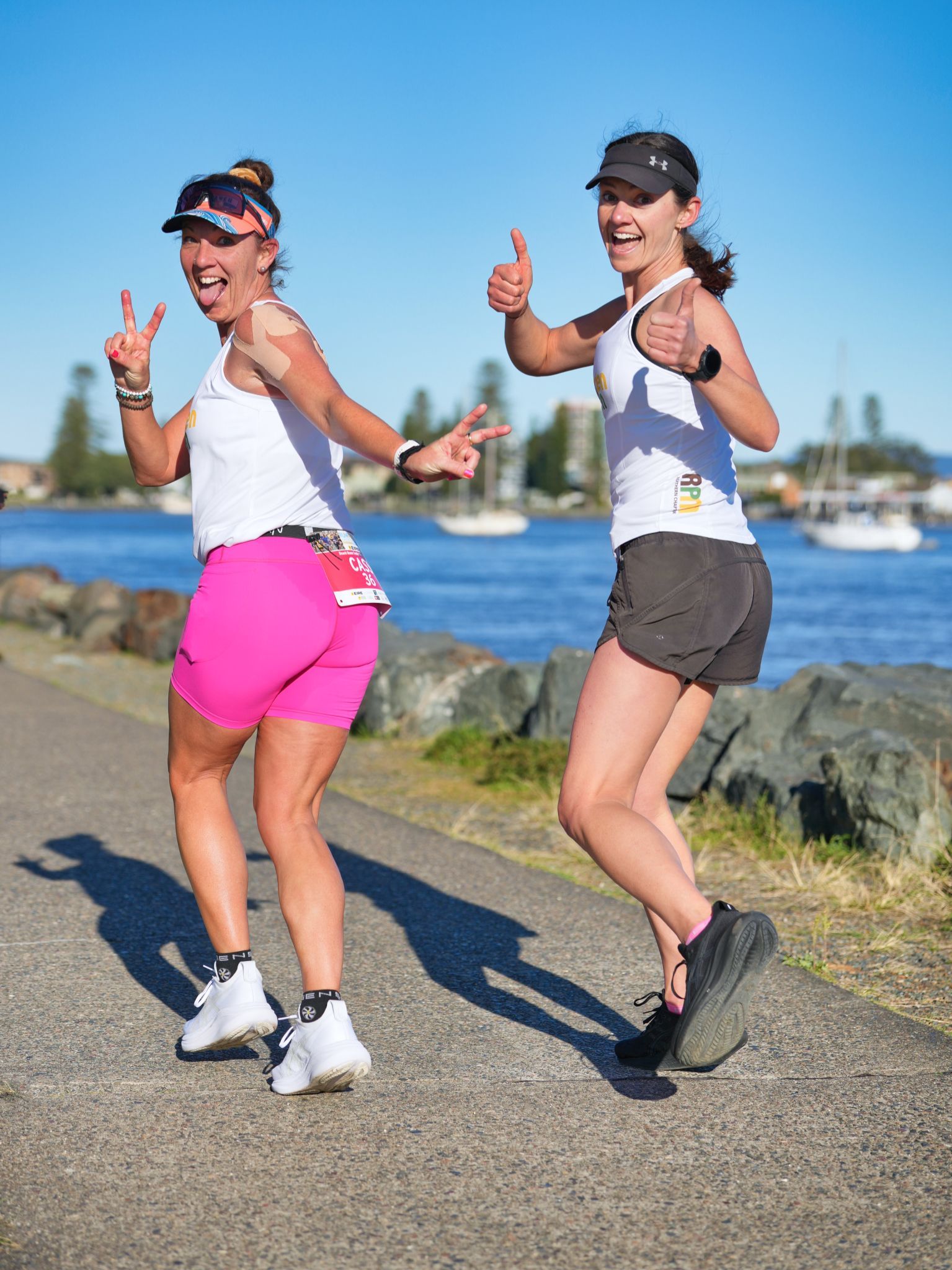 A Man Is Running On A Path In Front Of A Bridge Over A Body Of Water — Run Fest in Forster - Tuncurry, NSW