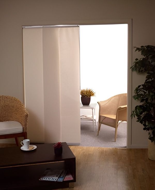 Beige Panel Blinds Covering Doorway to a Room With a Chair — NT Blinds in Yarrawonga, NT