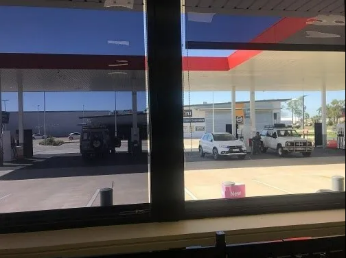 View From Inside a Building of a Gas Station With Pumps — NT Blinds in Yarrawonga, NT