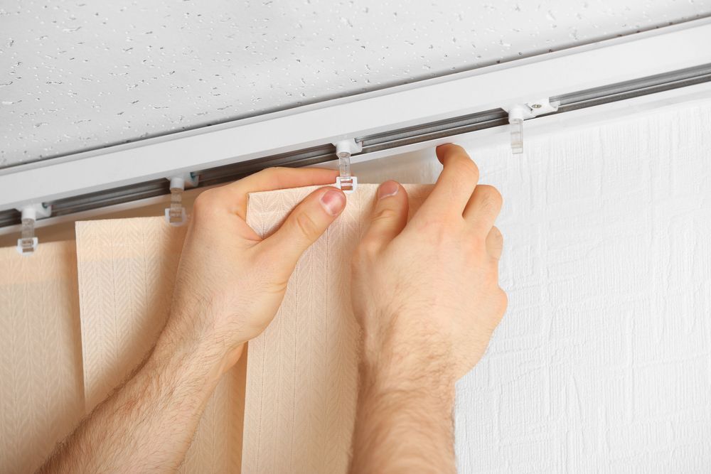 Hands Attaching Curtain Panels to a Track on a White Wall — NT Blinds in Yarrawonga, NT