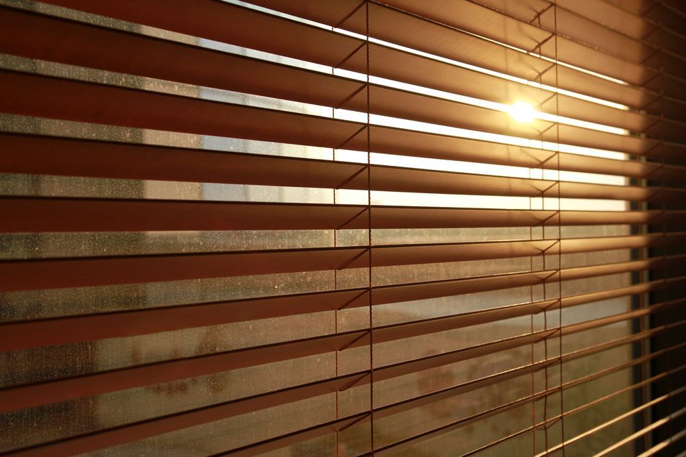 Wooden Blinds Allowing Slivers of Sunlight Into a Room — NT Blinds in Yarrawonga, NT