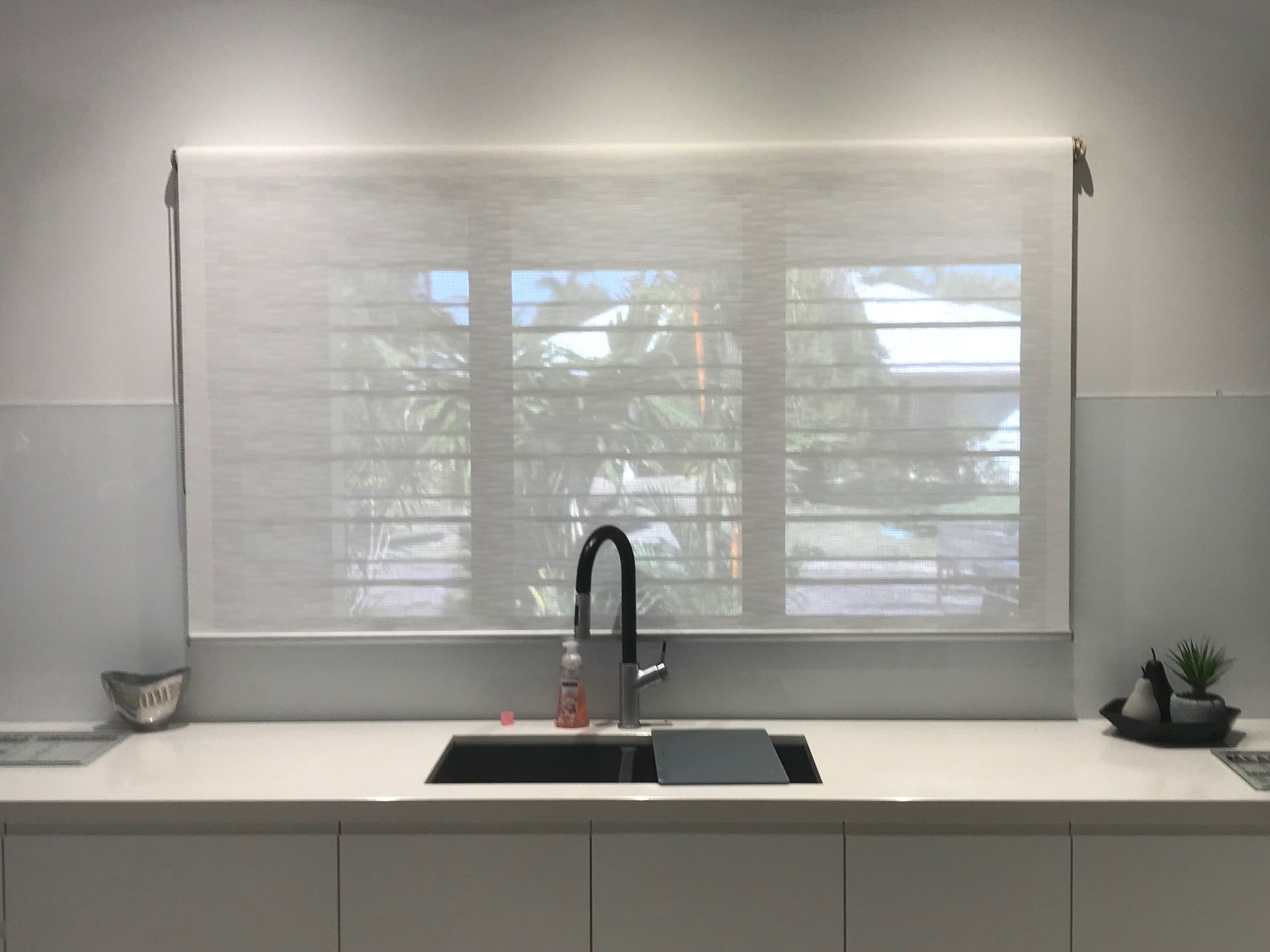 White kitchen window with sheer roller blind, above a sink and countertop  — NT Blinds in Coolalinga, NT