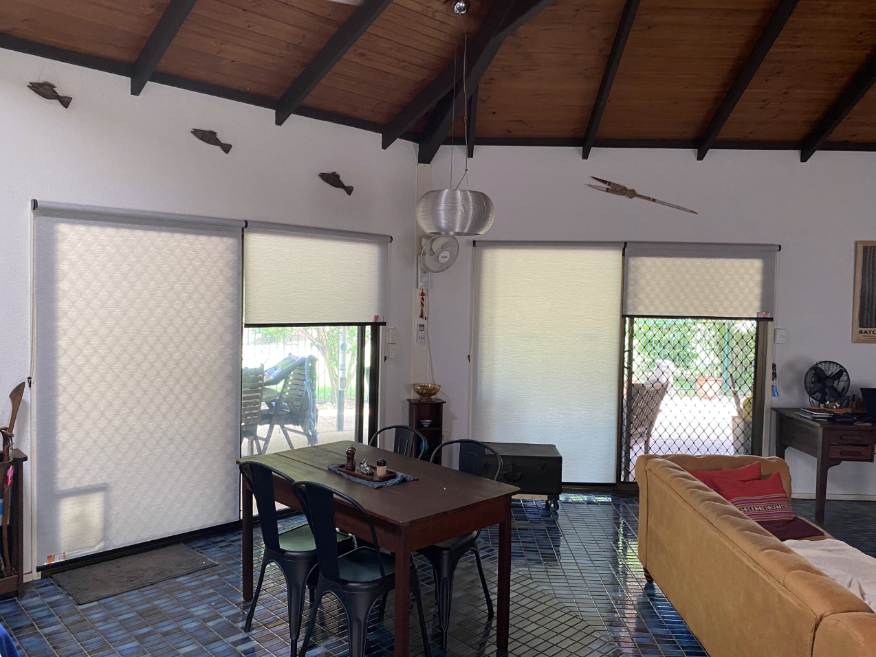 Interior with dining table, shades, and windows; a wooden beamed ceiling with decorative fish  — NT Blinds in Coolalinga, NT