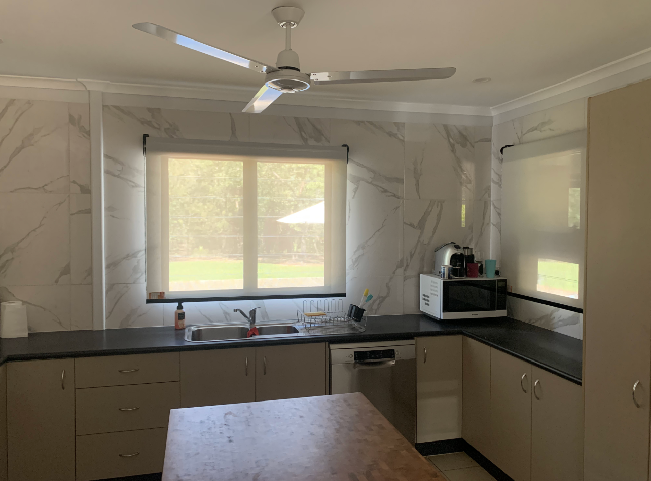 Kitchen with marble-look wall, dark countertops, a window, and a ceiling fan  — NT Blinds in Humpty Doo, NT