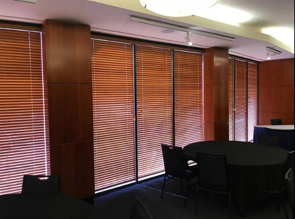 Dim Conference Room With Wooden Blinds Covering Large Windows — NT Blinds in Yarrawonga, NT