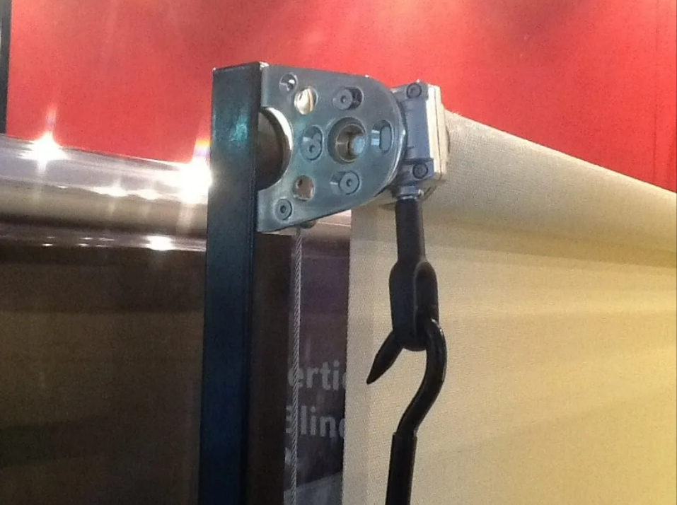 Close-up of a Metal Roller Bracket and Black Strap Against a Red Wall — NT Blinds in Yarrawonga, NT