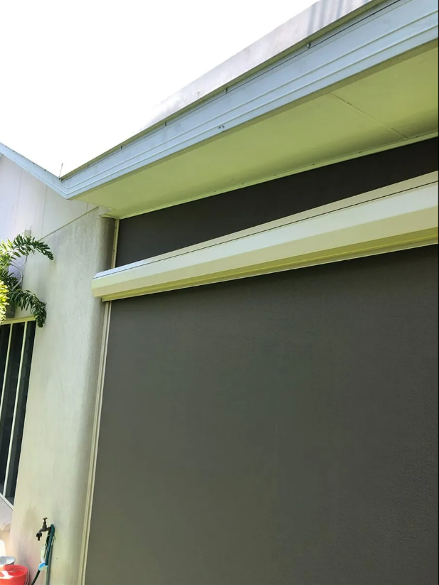 Exterior View of a Building With a Gray Roller Shade — NT Blinds in Yarrawonga, NT