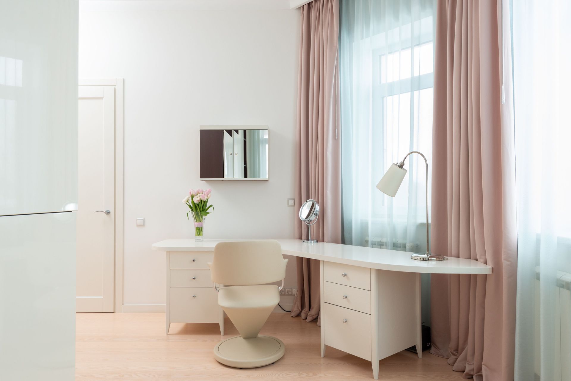 Bright minimalist home office with white desk, chair, mirror, lamp, and pink curtains by a window — NT Blinds in Yarrawonga, NT