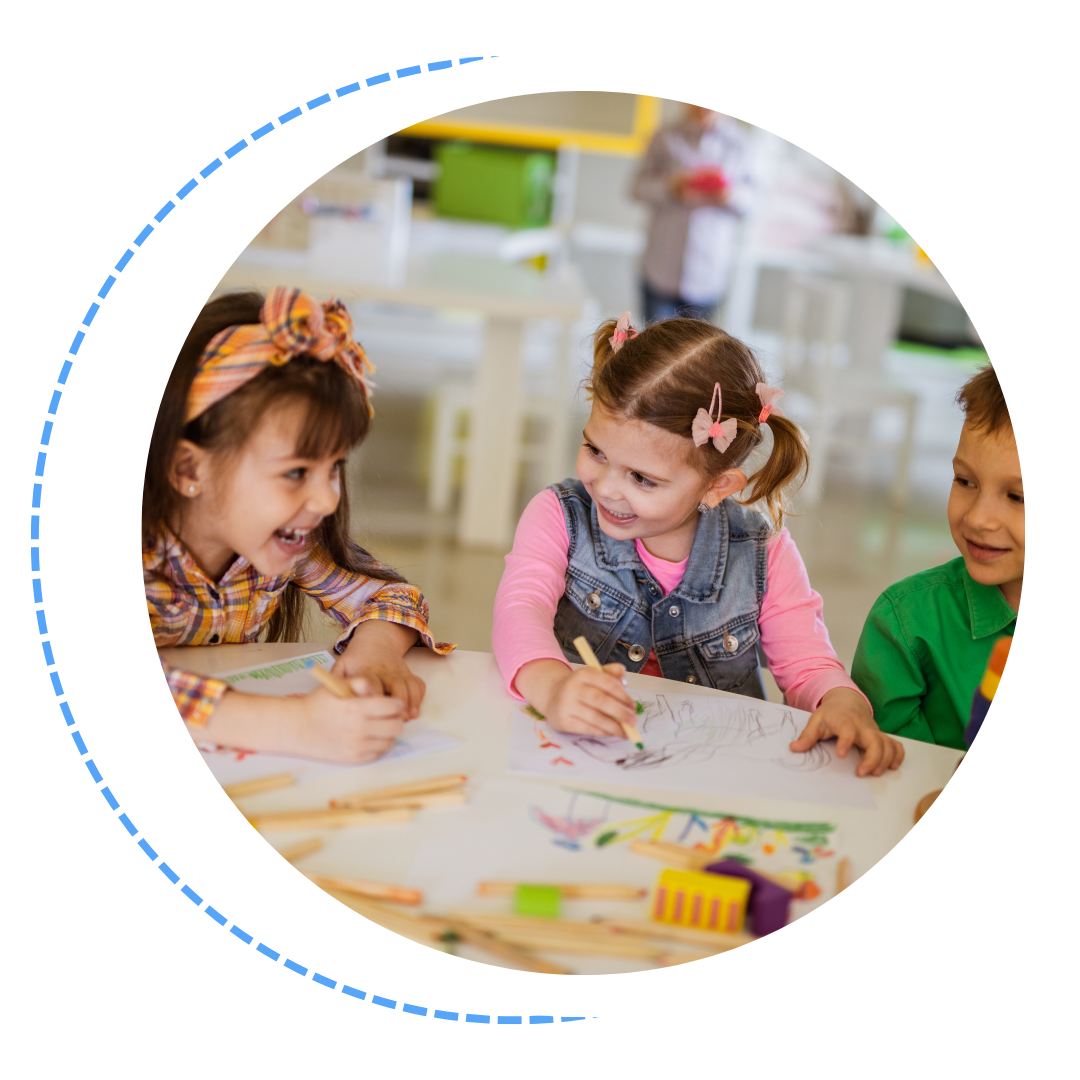 A group of children are sitting at a table drawing with pencils.