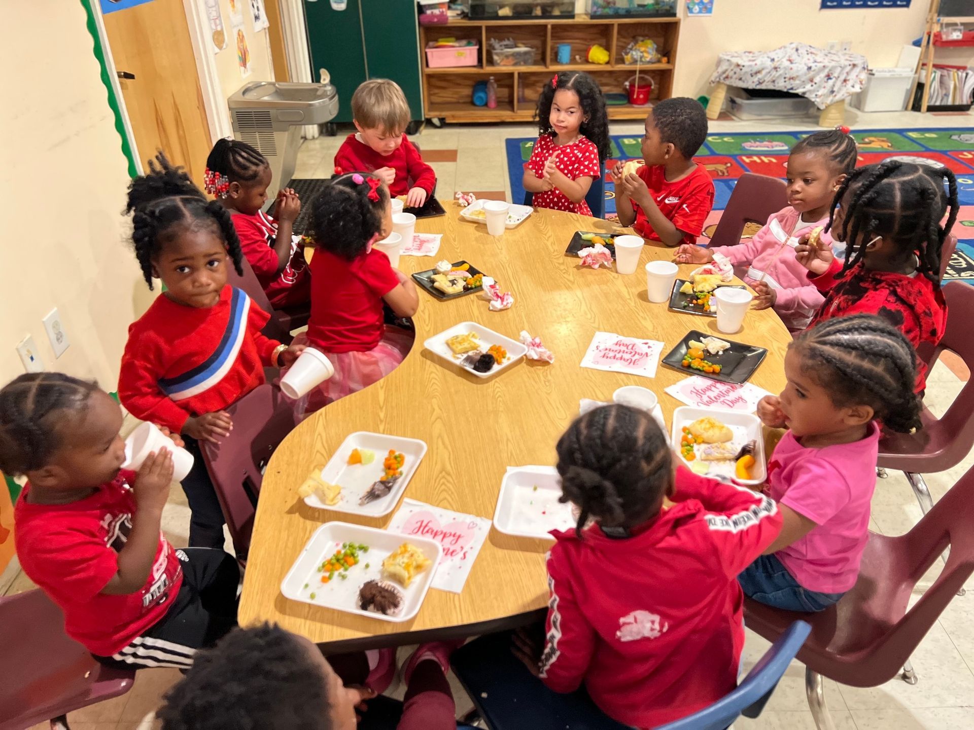 A group of children are sitting around a table eating food.