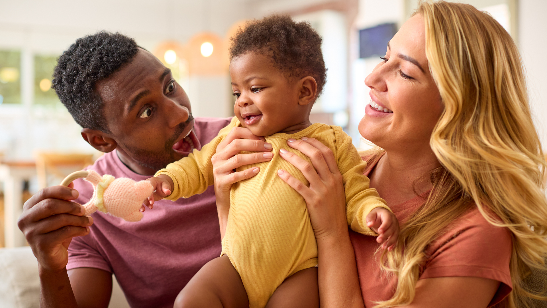 A man and a woman are holding a baby in their arms.