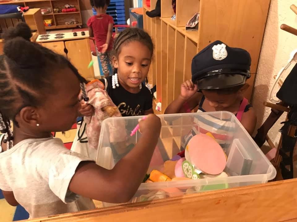A group of young girls are playing with toys in a room.