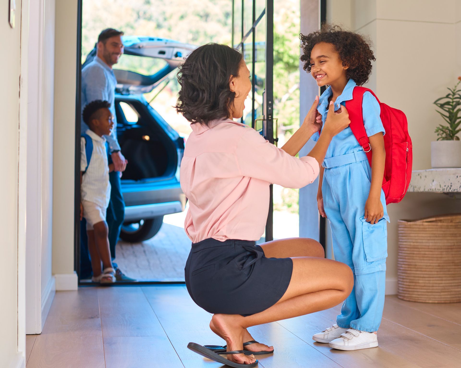 A woman is helping a young boy get ready for school.