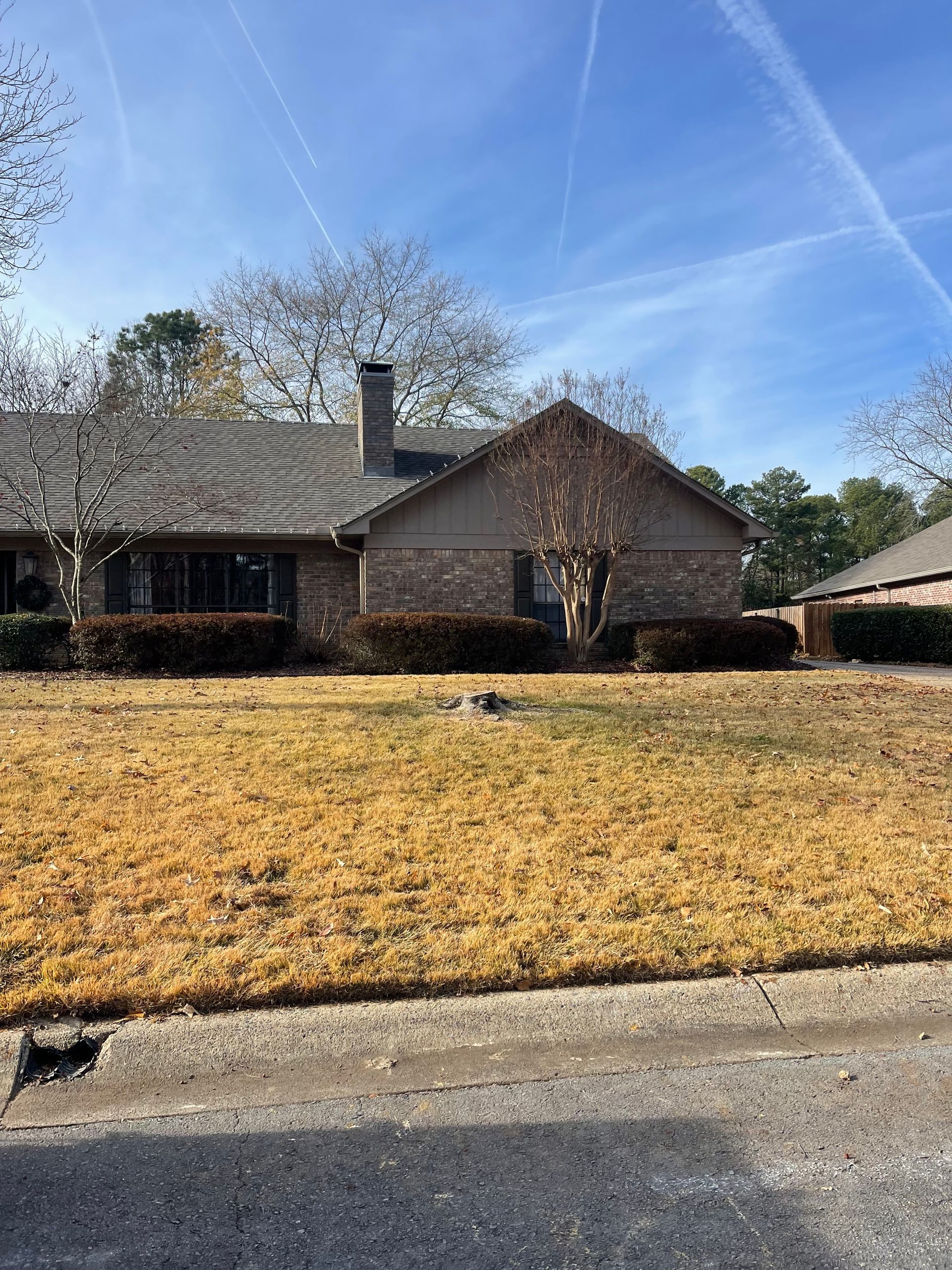 a house with a lush green lawn in front of it on a sunny day .