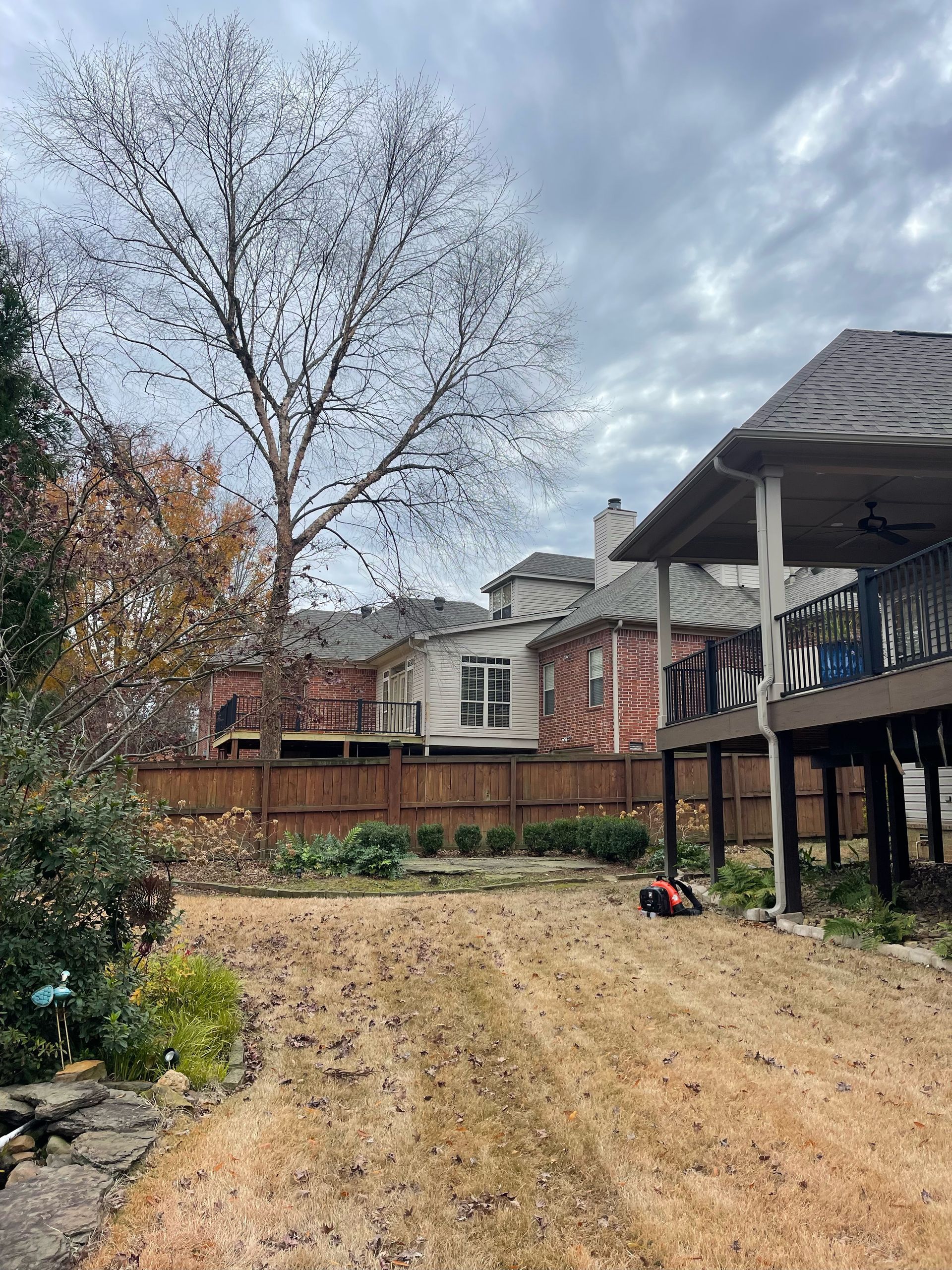 there is a lawn mower in the backyard of a house .