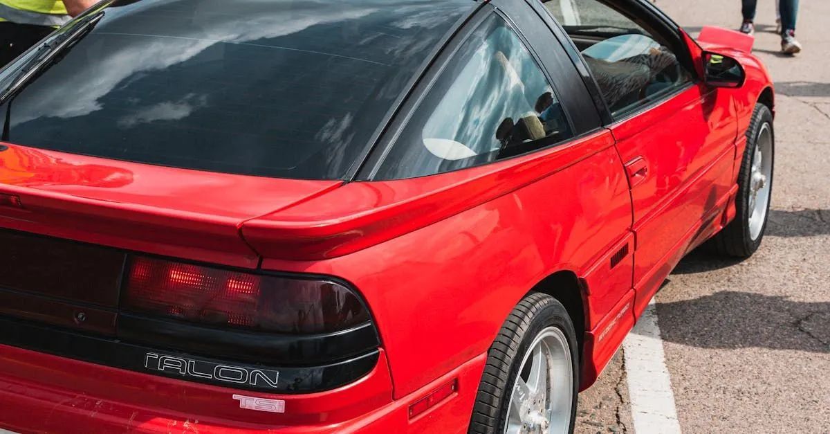 Red sports car parked outdoors. Features black accents, tinted windows, and gray wheels.