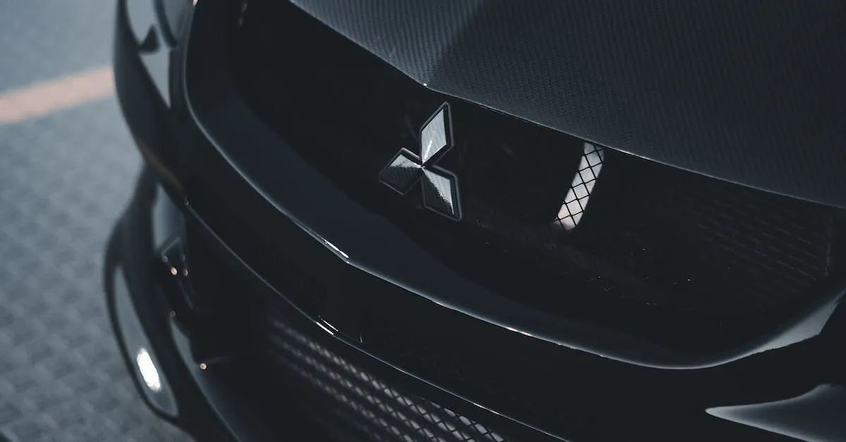 Close-up of a black Mitsubishi car's carbon fiber hood with the Mitsubishi logo in the center.