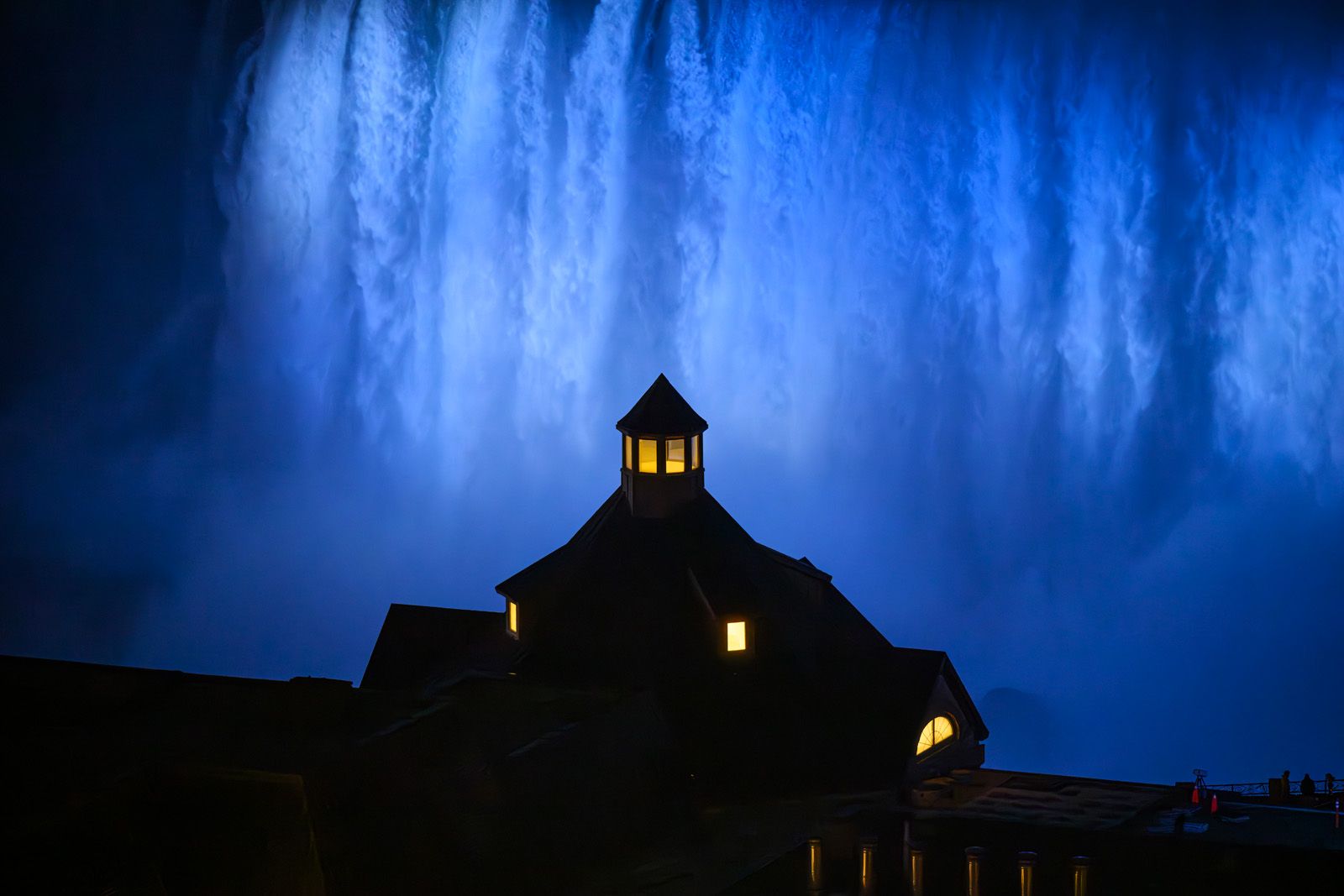 Table Rock at night lit by Niagara Falls under blue lights