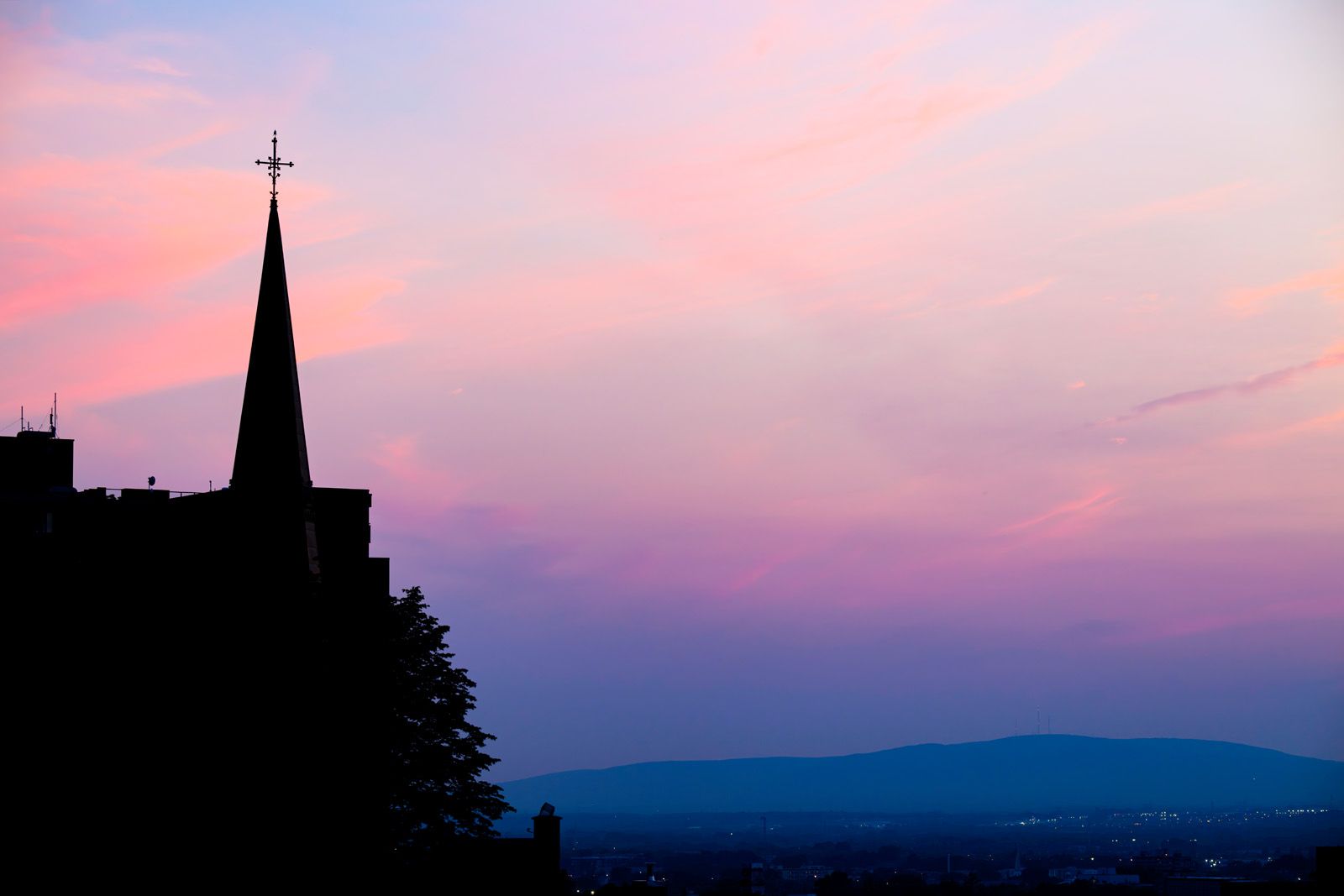 A steeple silhouetted at sunset as seen from the Hilton Quebec in Quebec City, QC.
