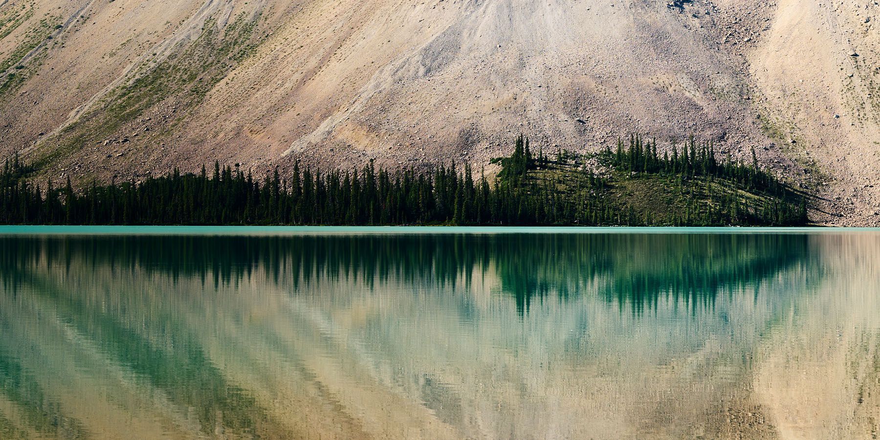 Beautiful reflection in calm waters at Bow Lake, Alberta, Canada.