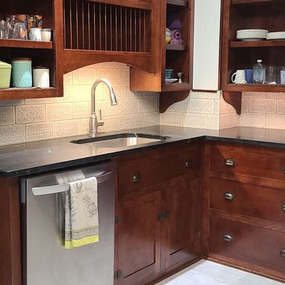 A kitchen with wooden cabinets and a stainless steel dishwasher