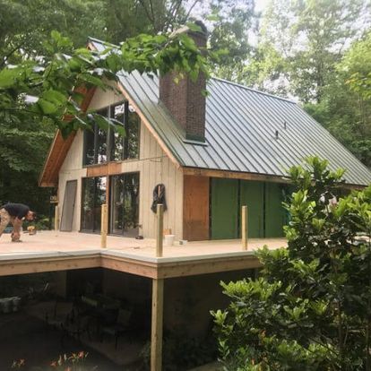 A house with a metal roof and a wooden deck