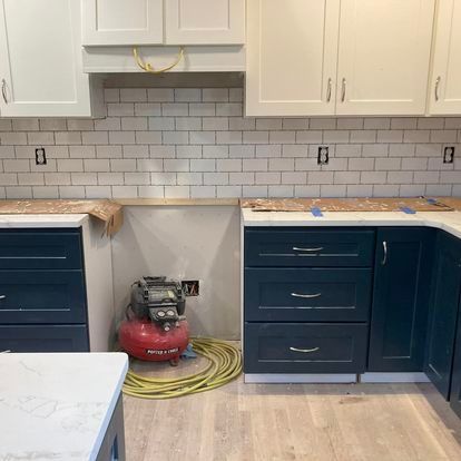 A kitchen with blue cabinets and white cabinets is being remodeled.