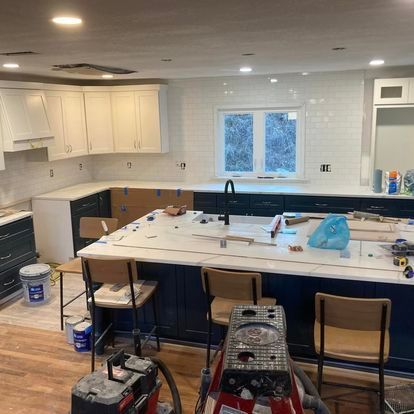 A kitchen is being remodeled with blue cabinets and white counter tops.