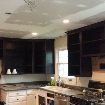 A kitchen with black cabinets and white counter tops