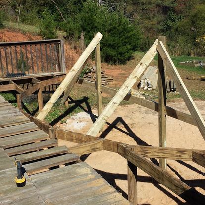 A wooden structure is being built with a drill on the ground.