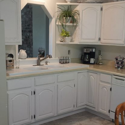 A kitchen with white cabinets and a sink