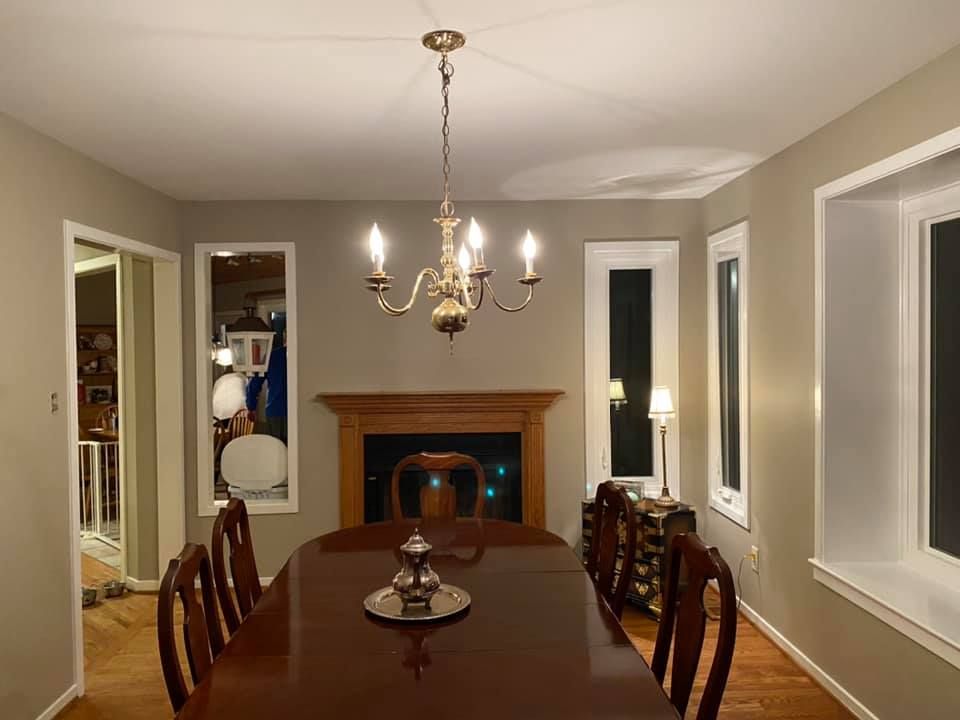 A white house with a lot of windows and a brick porch.