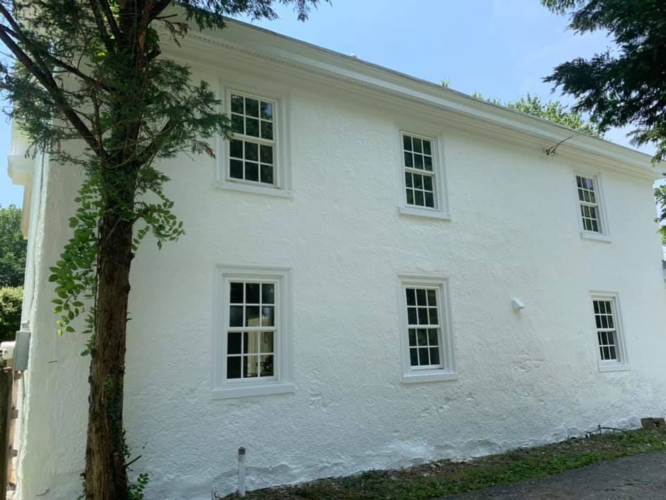 A corner of a room with a brick wall and a wooden cabinet.