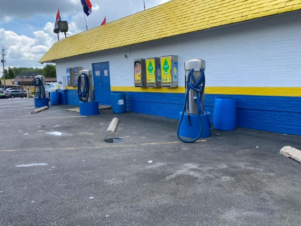 A car wash with a yellow roof and blue walls