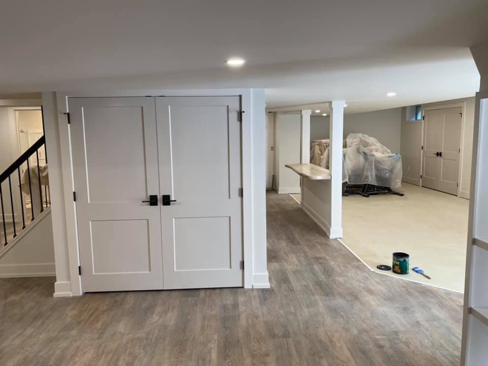 A basement with hardwood floors and white doors.