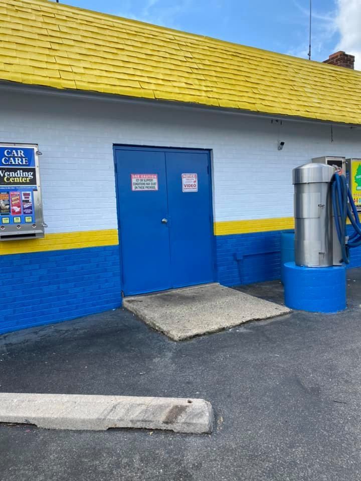 A yellow roof is being painted on a building next to a ladder.