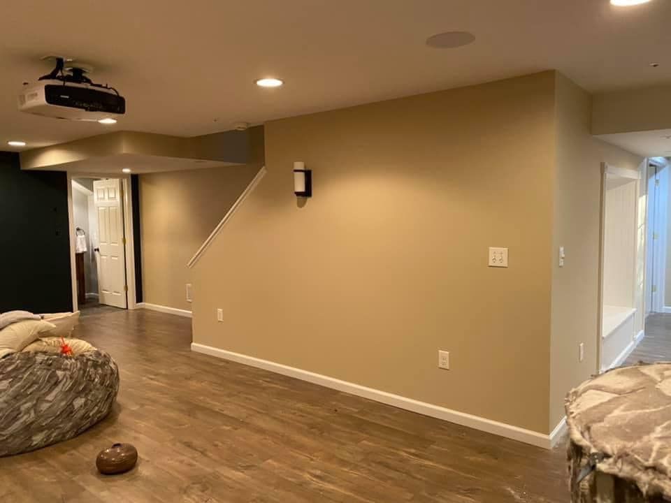 A living room in a basement with a projector on the wall.