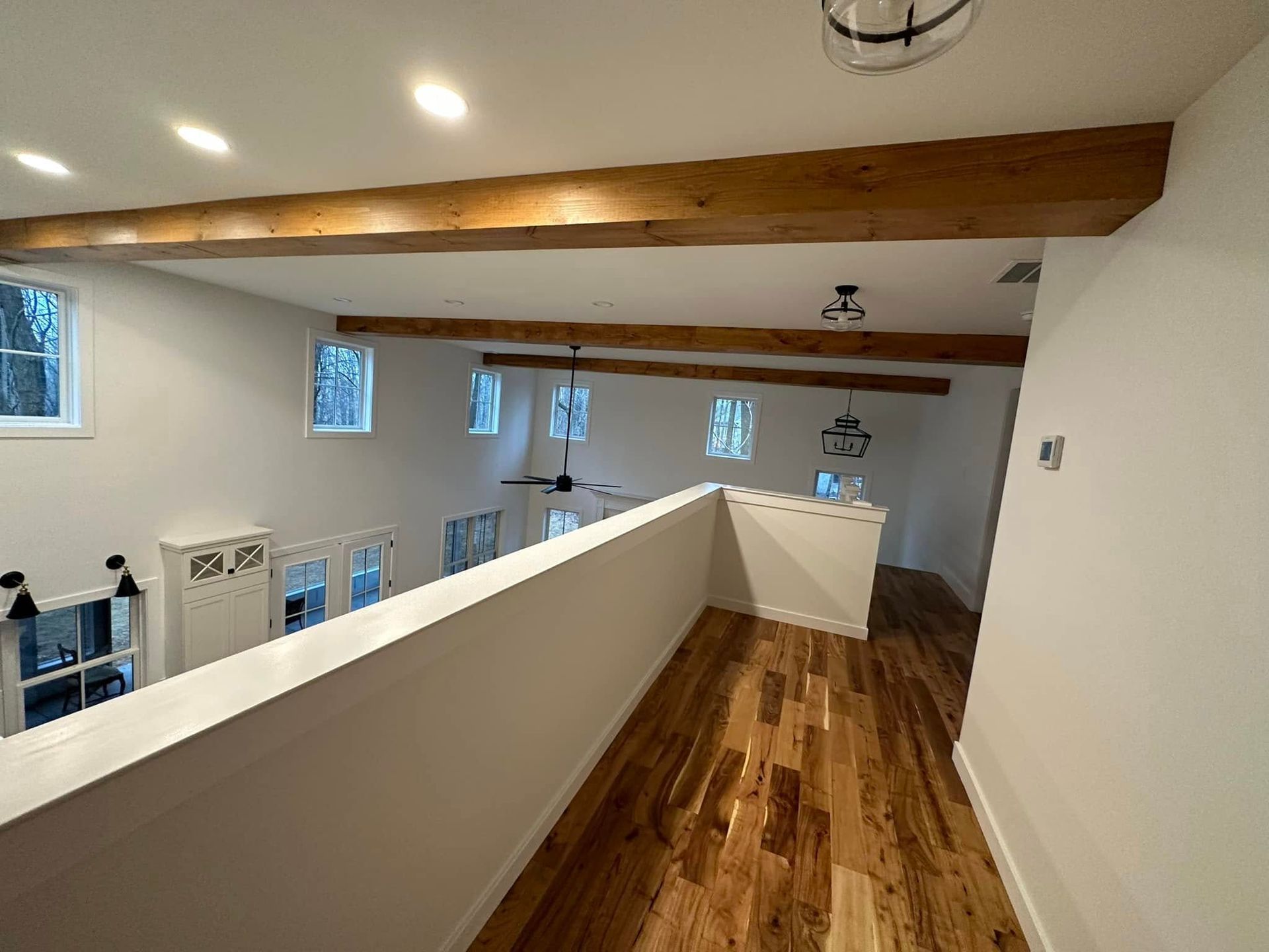 A hallway with hardwood floors and wooden beams in a house.