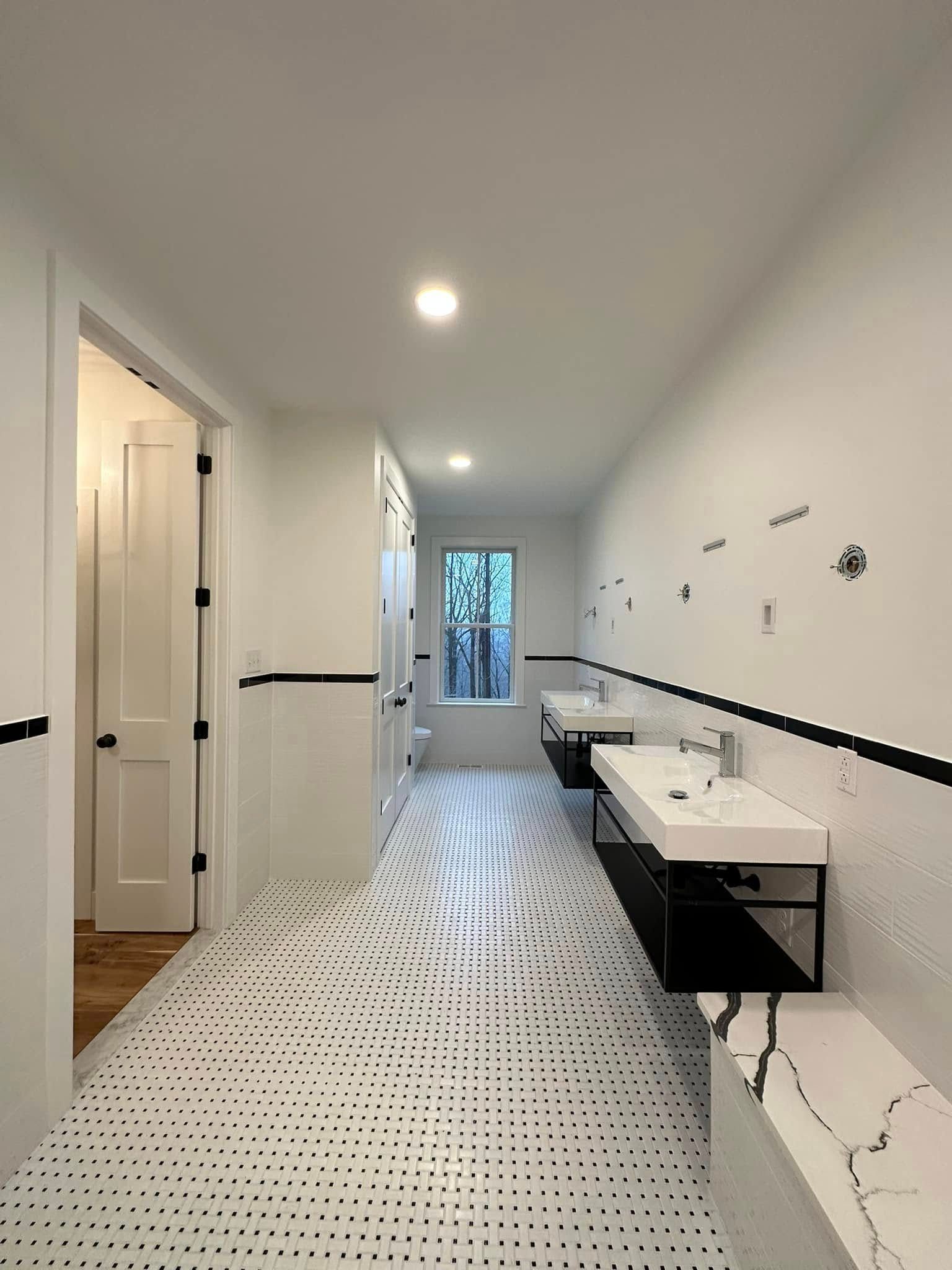 A bathroom with two sinks , a toilet and a window.