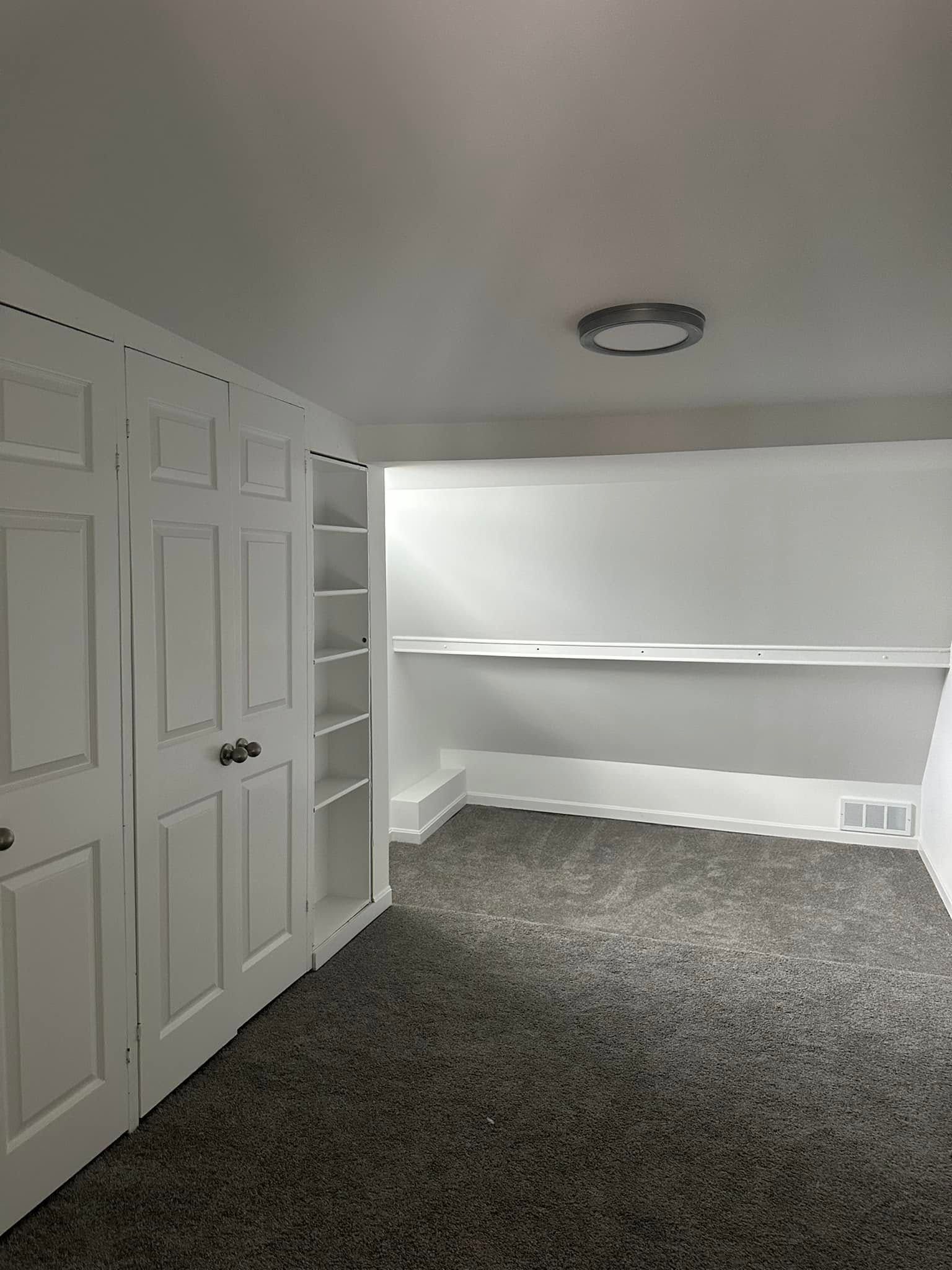 There is a desk in the corner of the room.