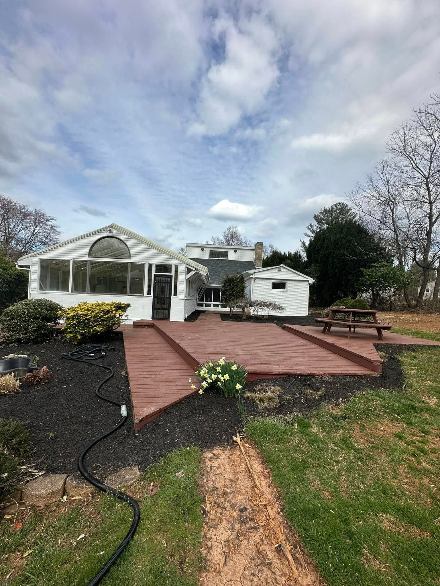 A large white house with a large deck in front of it.