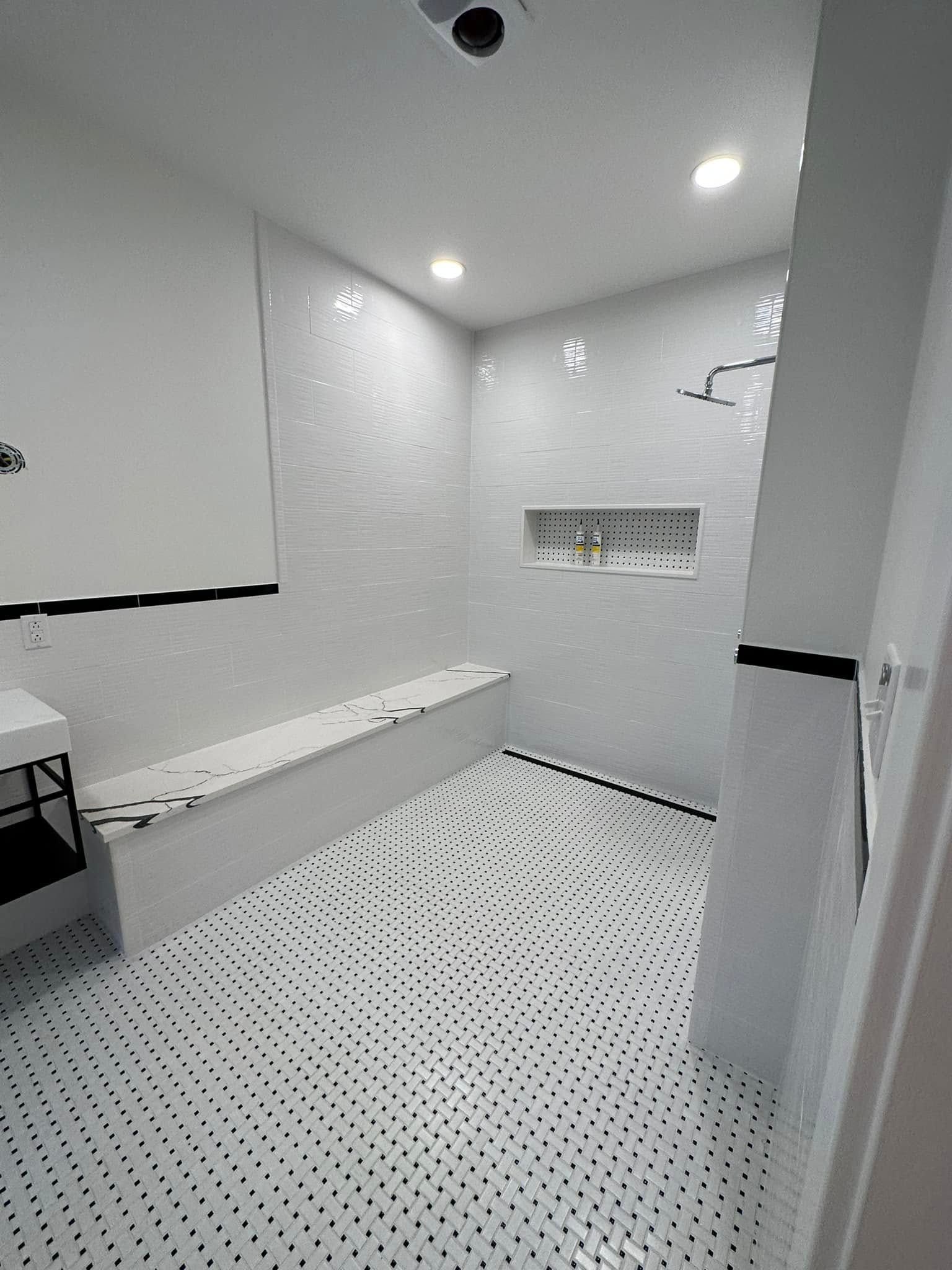 A bathroom with a walk in shower and a bench.