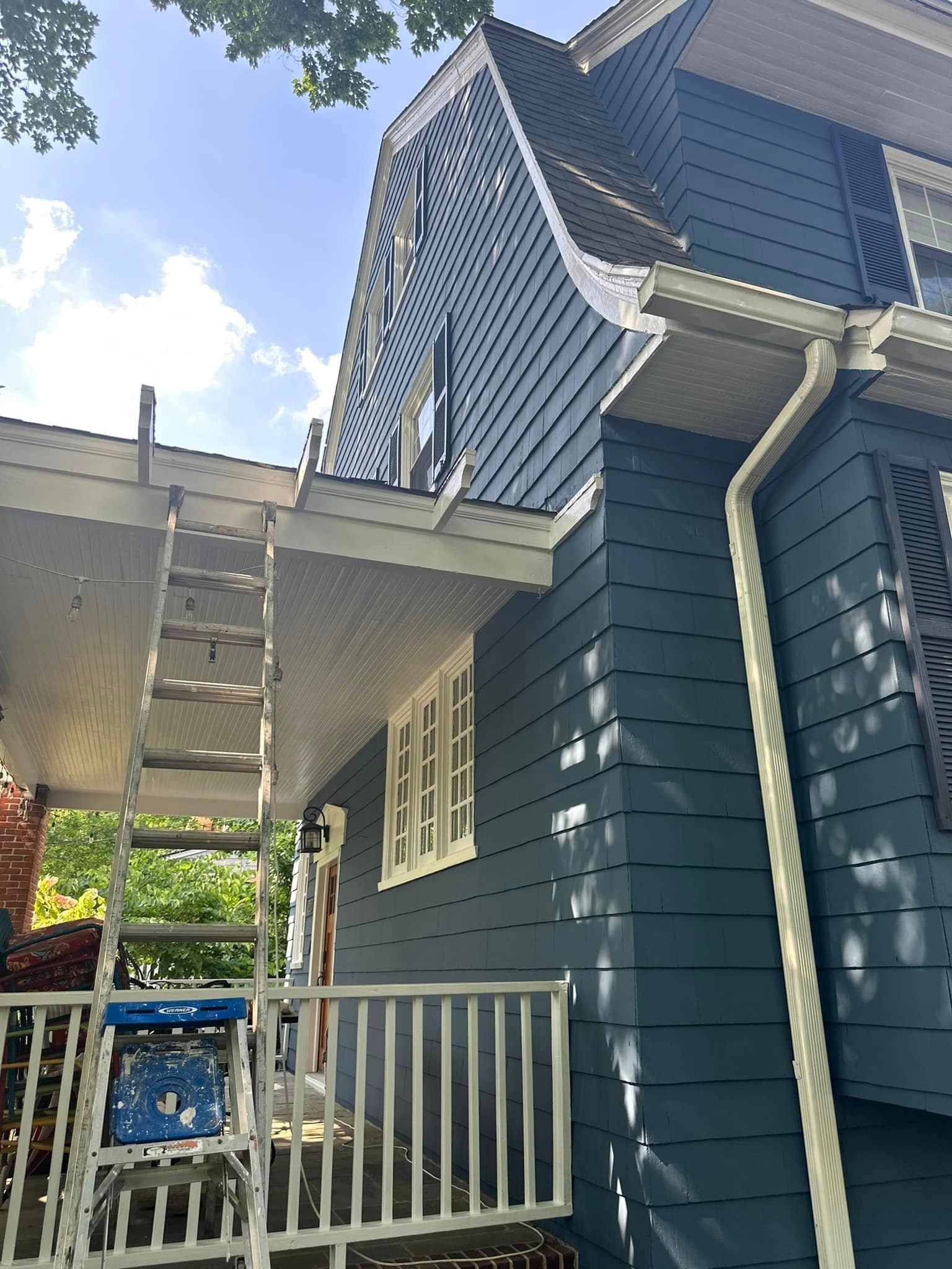 A blue house with a ladder on the side of it