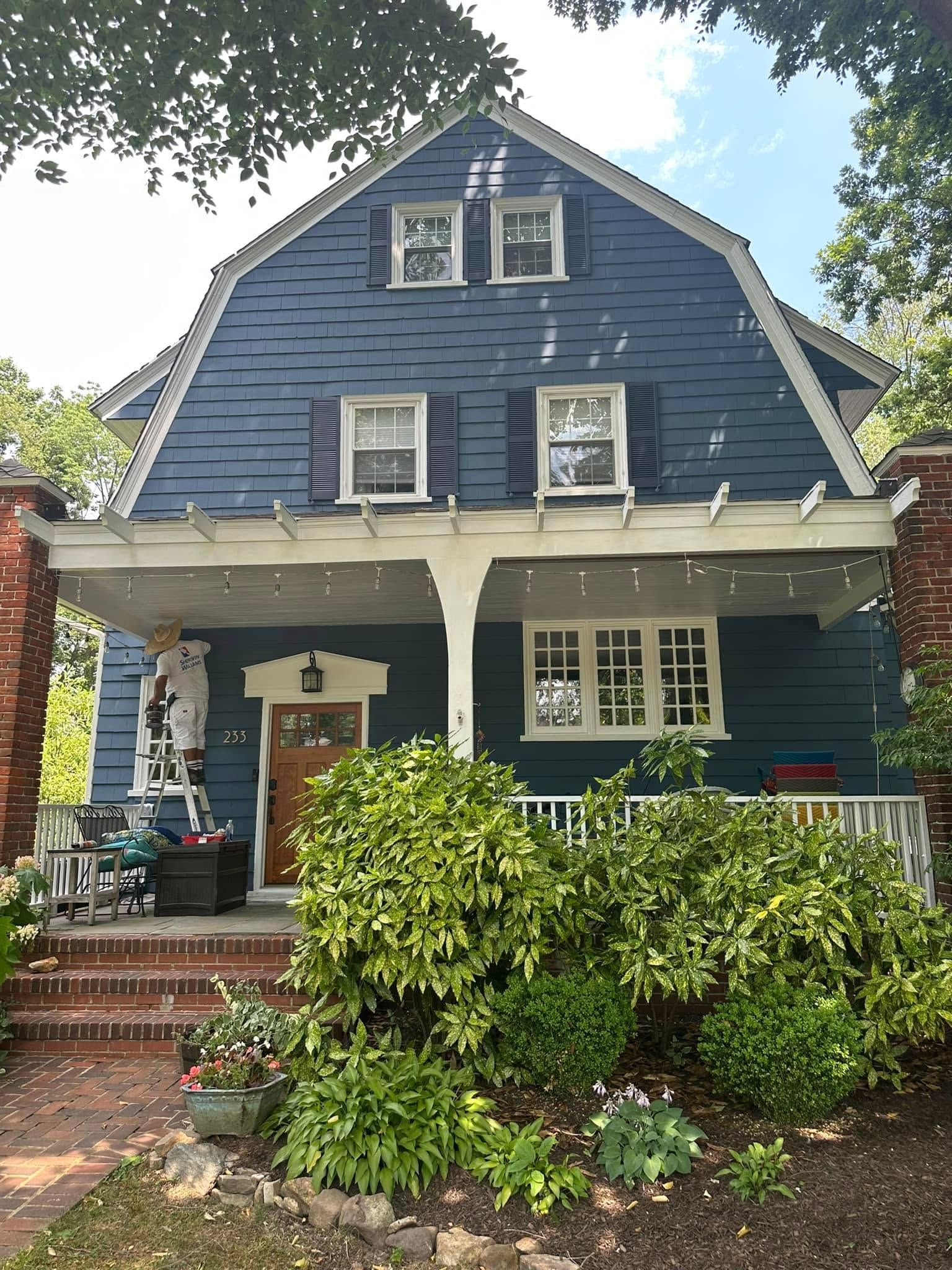 A blue house with white shutters and a porch