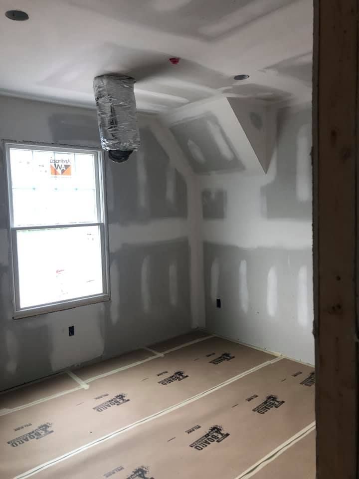 A room with drywall on the walls and a window.