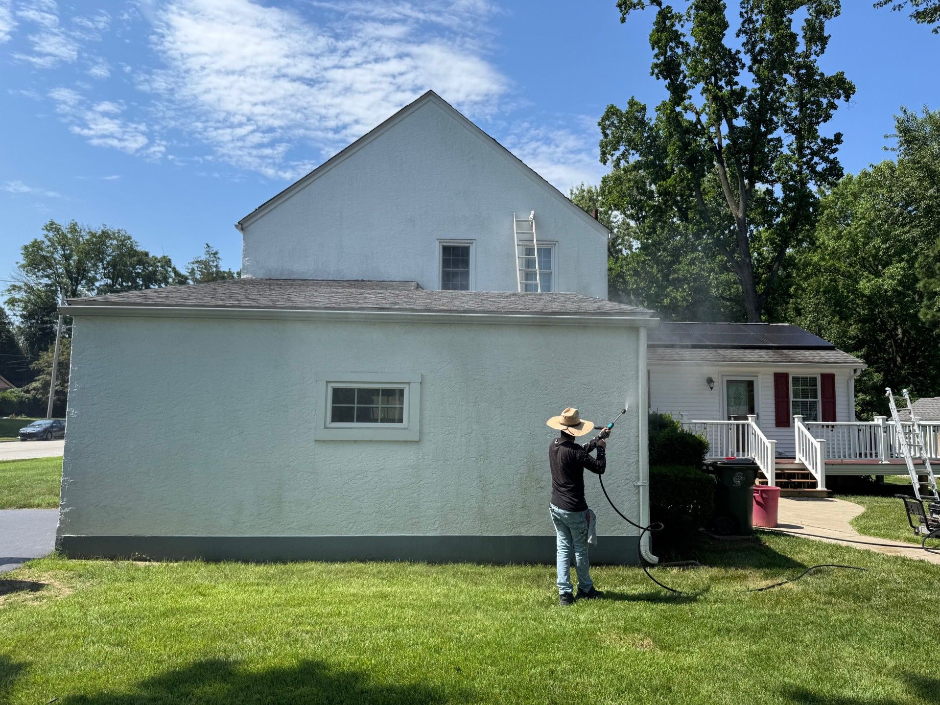 A man is painting the side of a house.
