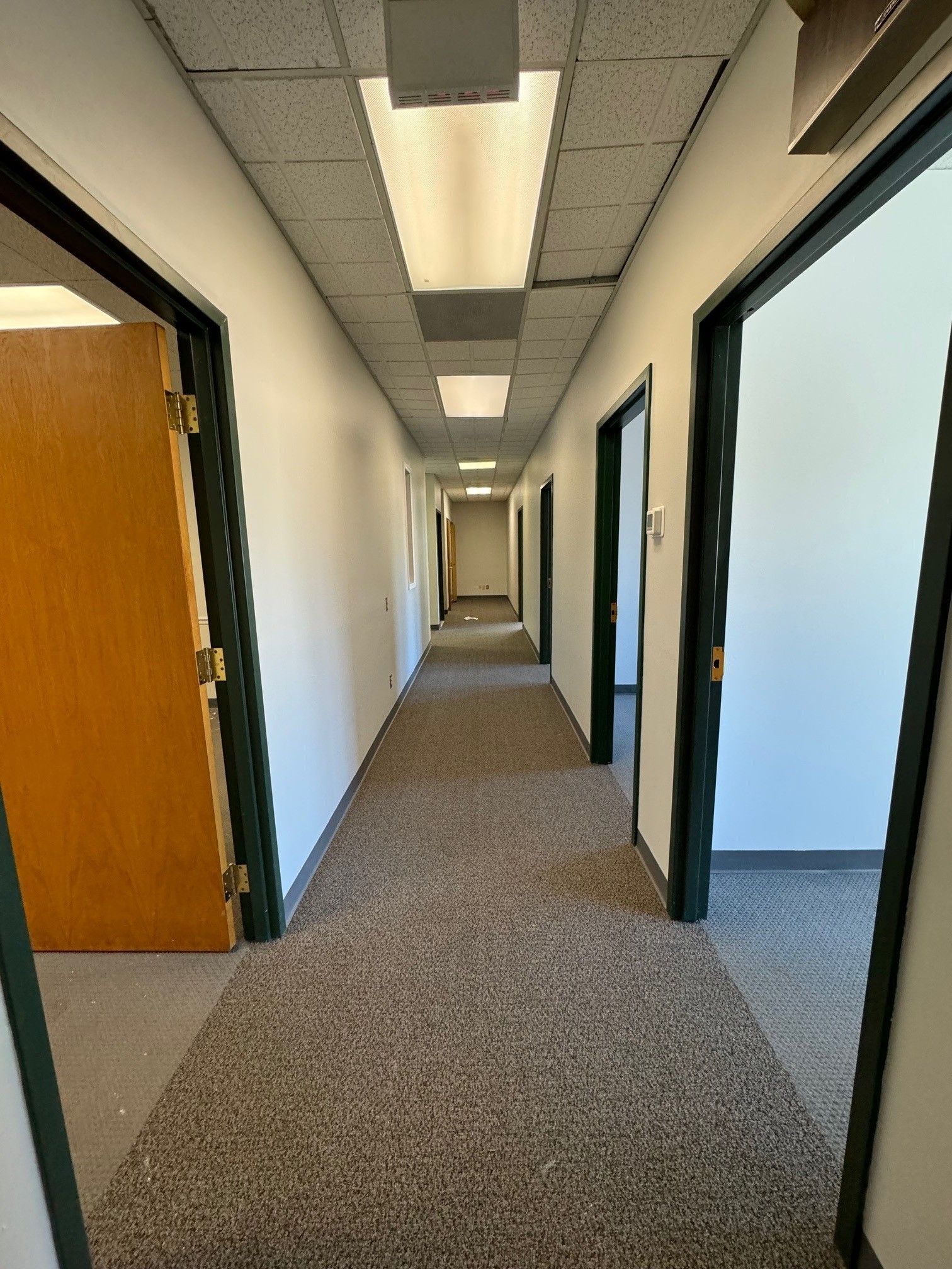 A hallway with a red exit sign on the wall
