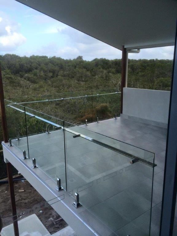 A Balcony With A Glass Railing And A View Of A Forest — Frameless Shower Installations In Maroochydore, QLD